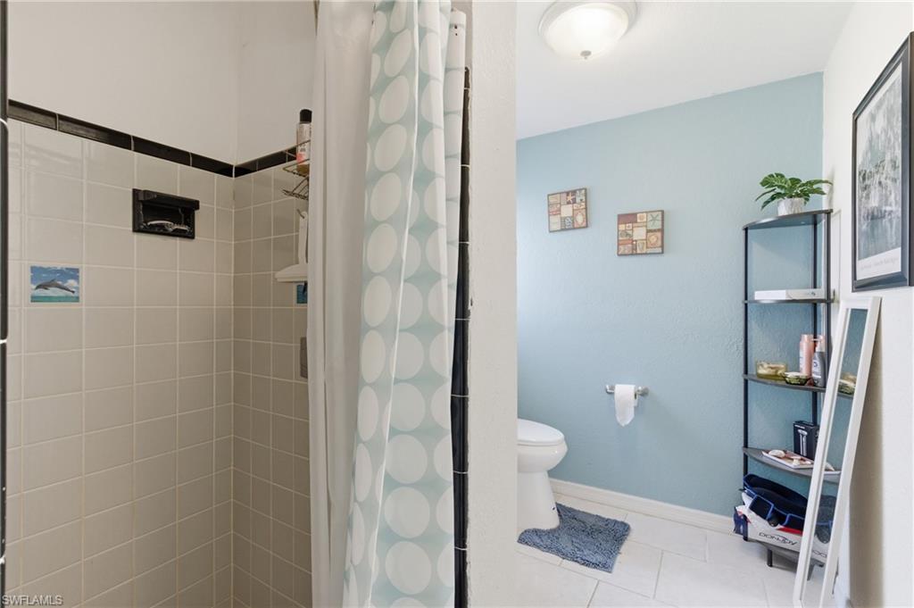 Bathroom with a shower stall and light tile patterned floors