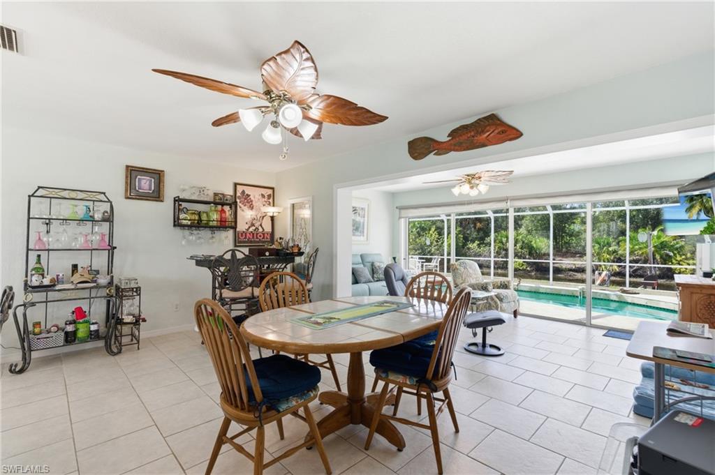 Dining space featuring ceiling fan, light tile patterned floors, and a sunroom
