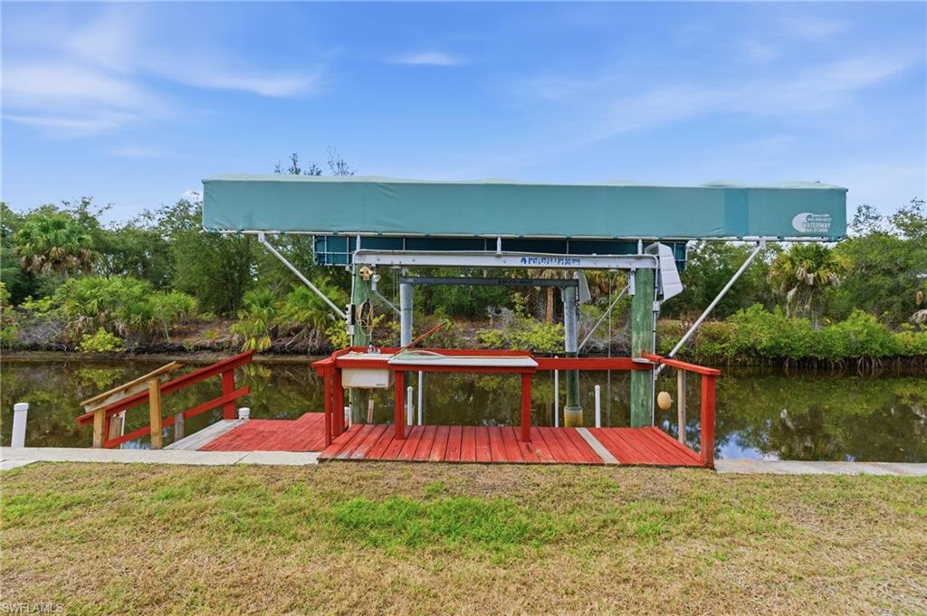 Dock with a water view, a lawn, and boat lift
