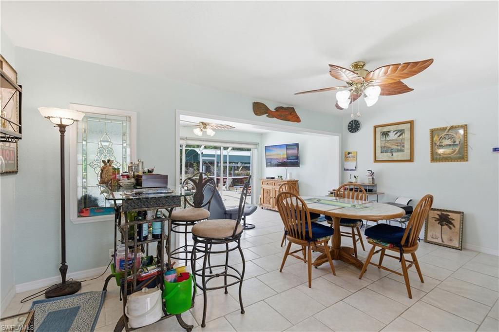 Dining space with a ceiling fan and light tile patterned floors