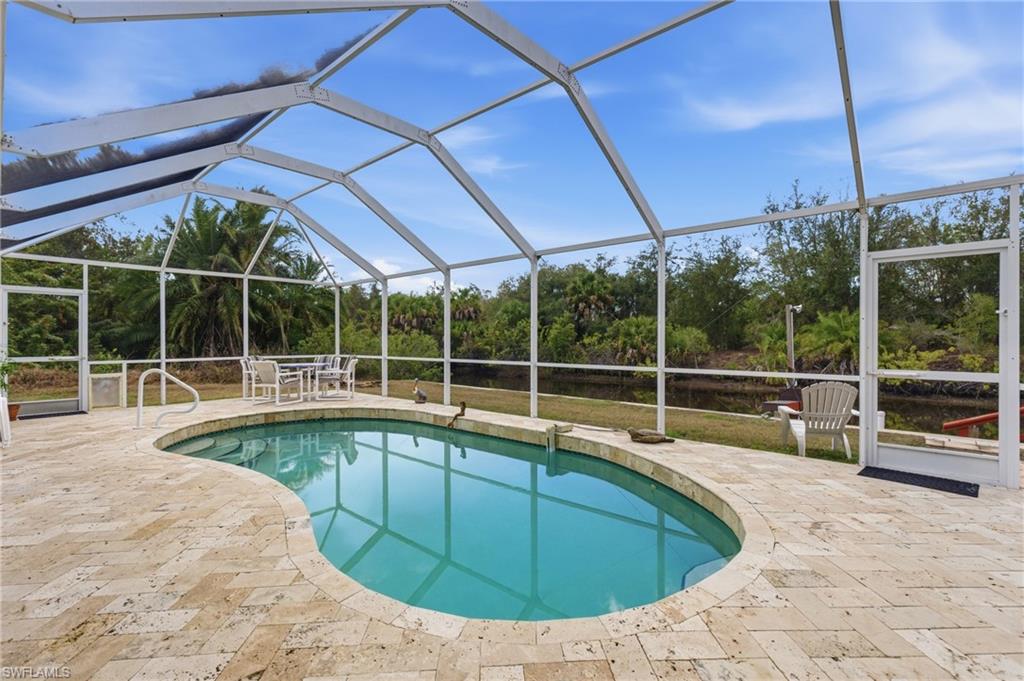 Swimming pool featuring a lanai, a sunroom, and a patio area