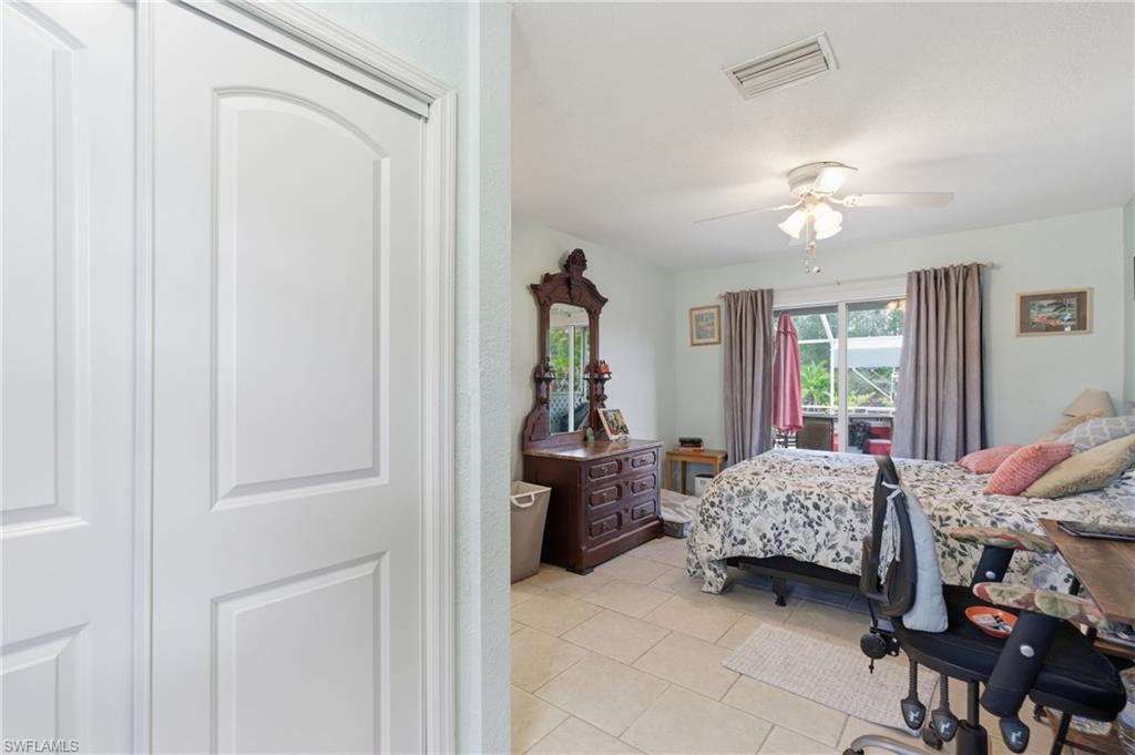 Bedroom with light tile patterned floors and ceiling fan