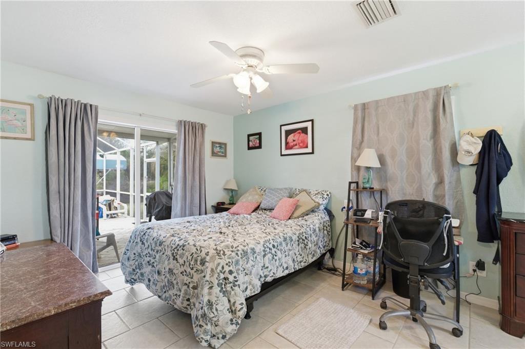 Bedroom featuring access to exterior, a desk, a ceiling fan, and light tile patterned floors