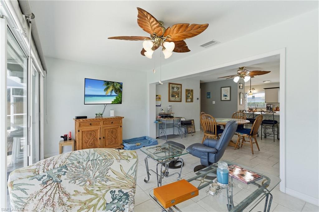 Living area with ceiling fan and light tile patterned floors