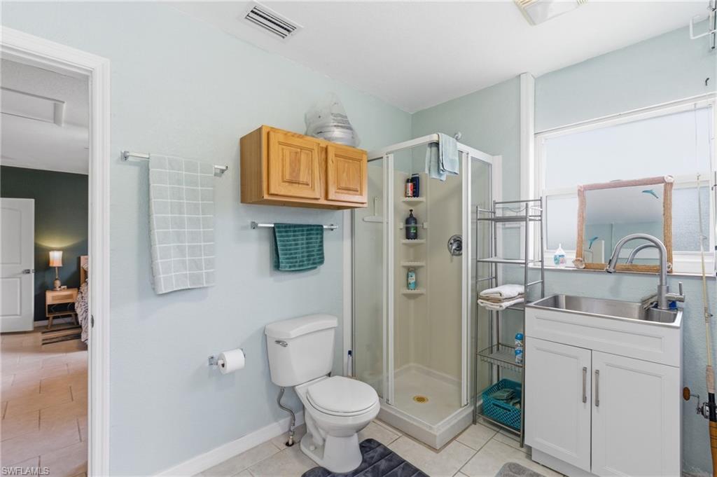 Bathroom with vanity, light tile patterned floors, and a shower stall