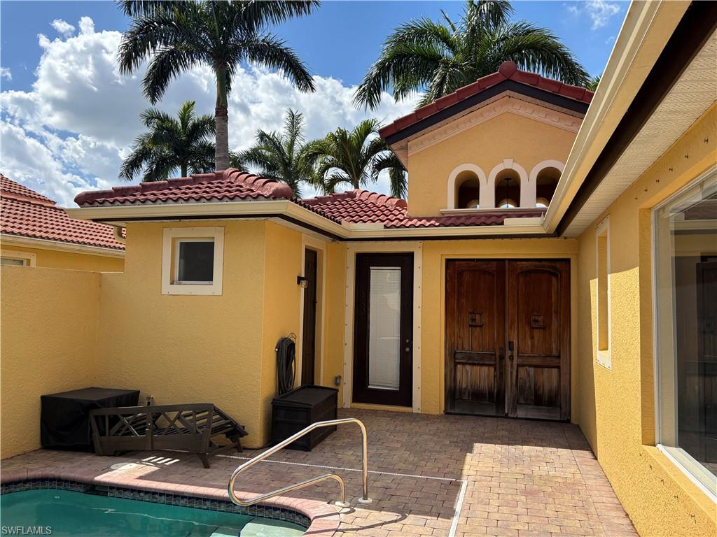 Back of house with a patio, stucco siding, an outdoor pool, and a tile roof