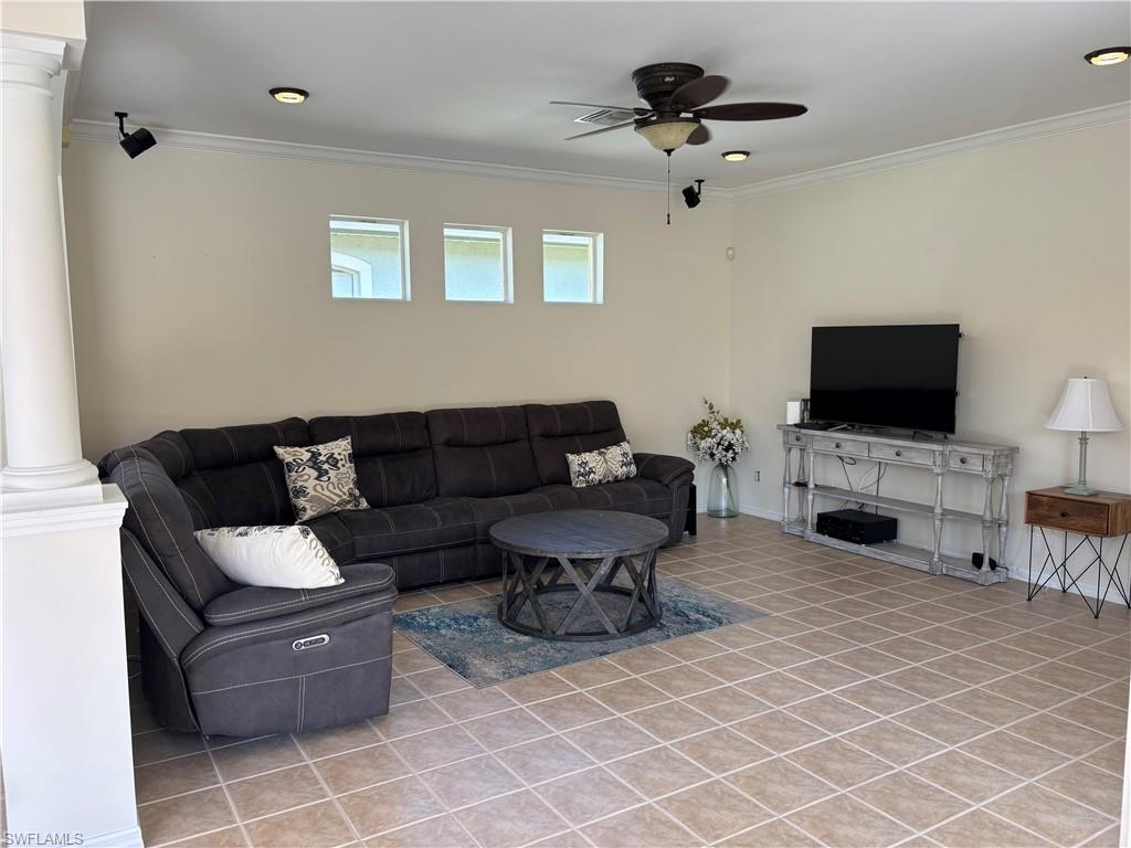 Living area featuring decorative columns, ceiling fan, ornamental molding, recessed lighting, and light tile patterned floors