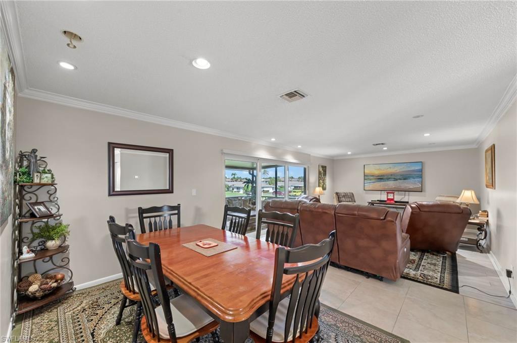 Dining space featuring crown molding, recessed lighting, and light tile patterned flooring