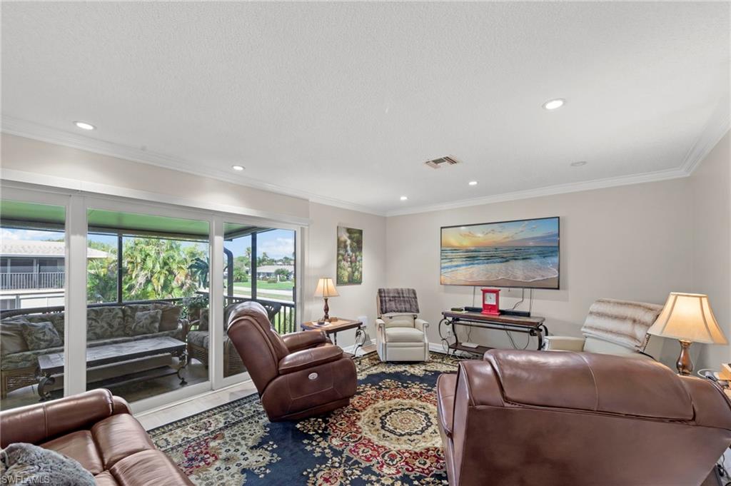 Living room with ornamental molding and recessed lighting
