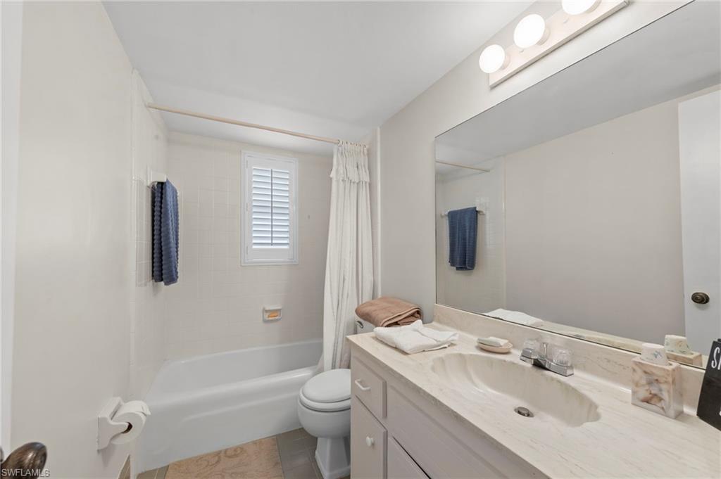 Guest Bathroom with vanity, shower / bath combo, and light tile patterned floors