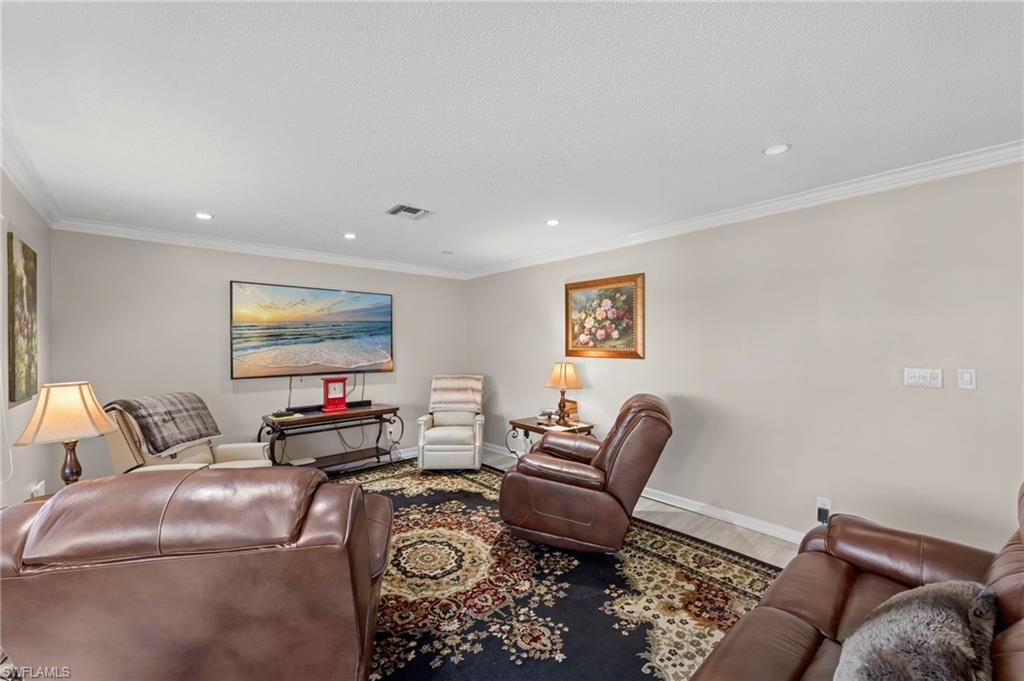 Living area featuring ornamental molding, recessed lighting, and wood finished floors