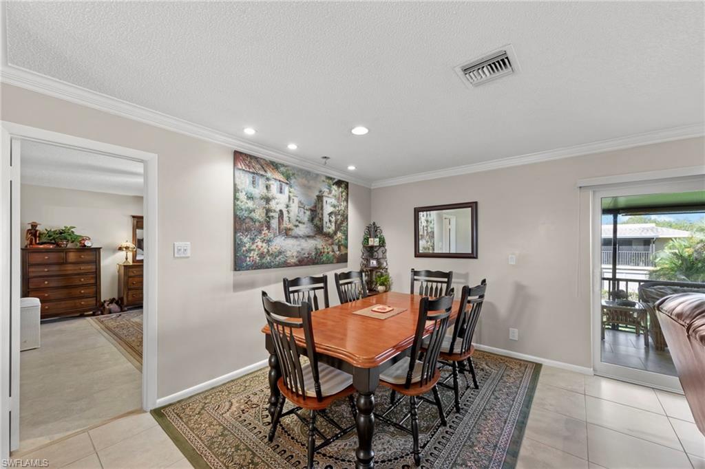 Dining area with ornamental molding, recessed lighting, light tile patterned flooring, and a textured ceiling