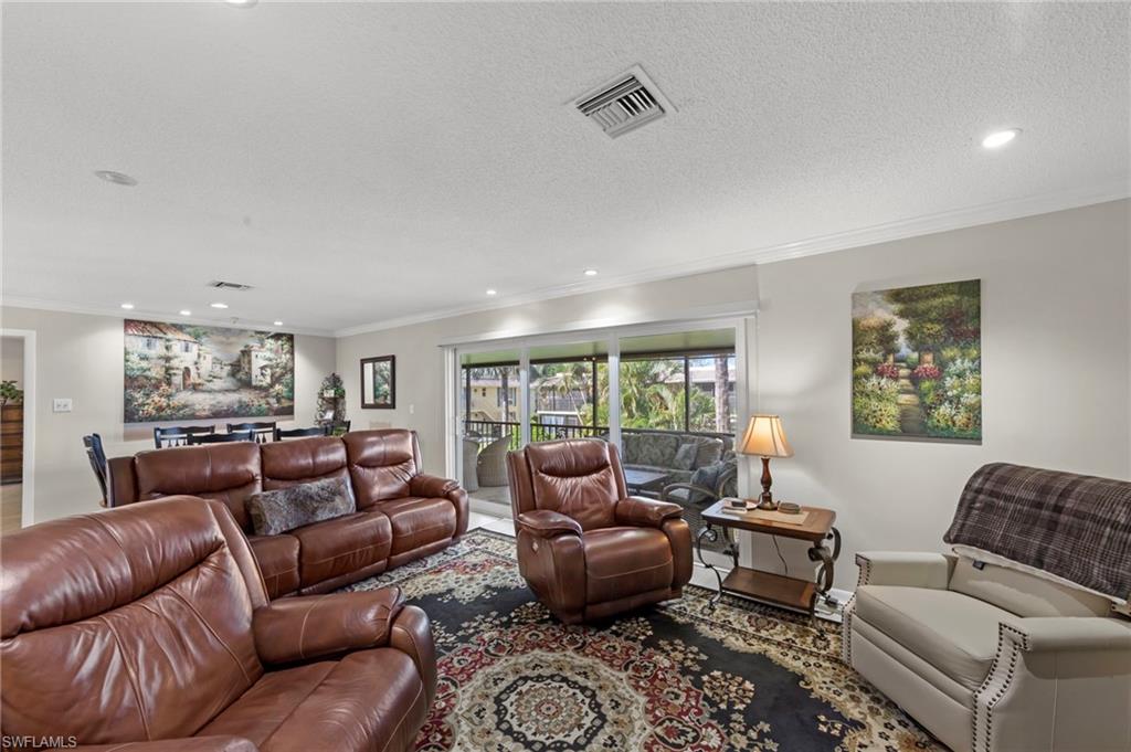 Living area with recessed lighting, crown molding, and a textured ceiling