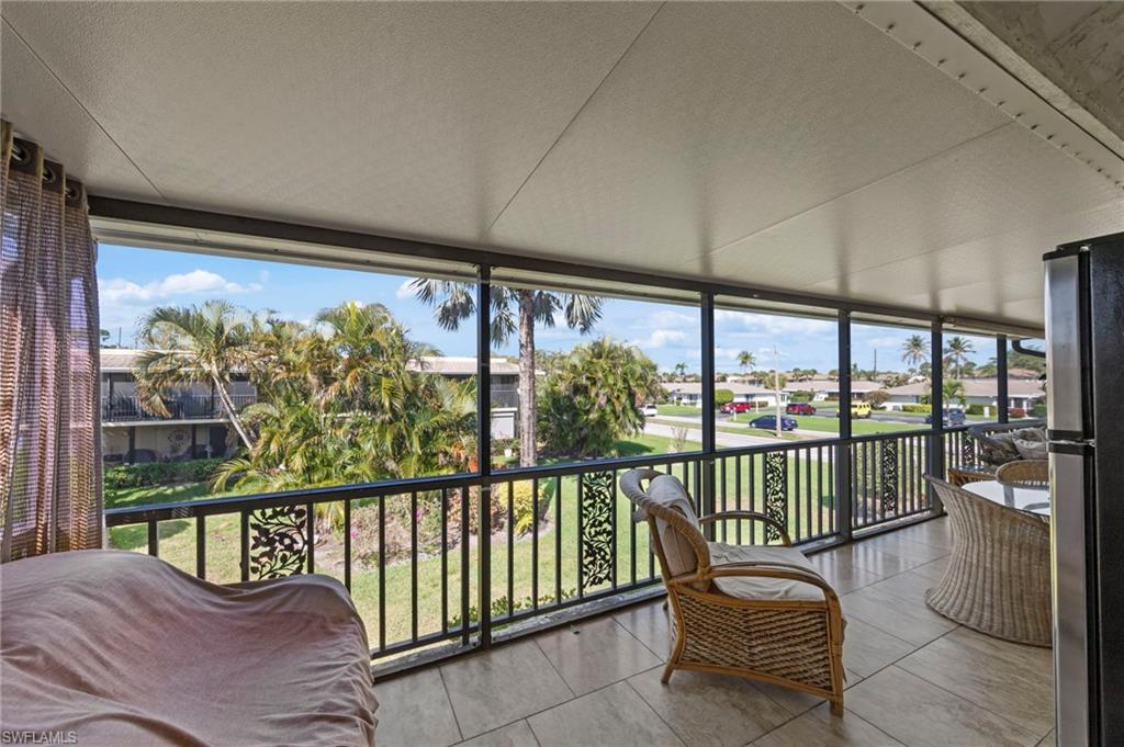 Sunroom / solarium with a textured ceiling, floor to ceiling windows, and tile patterned floors