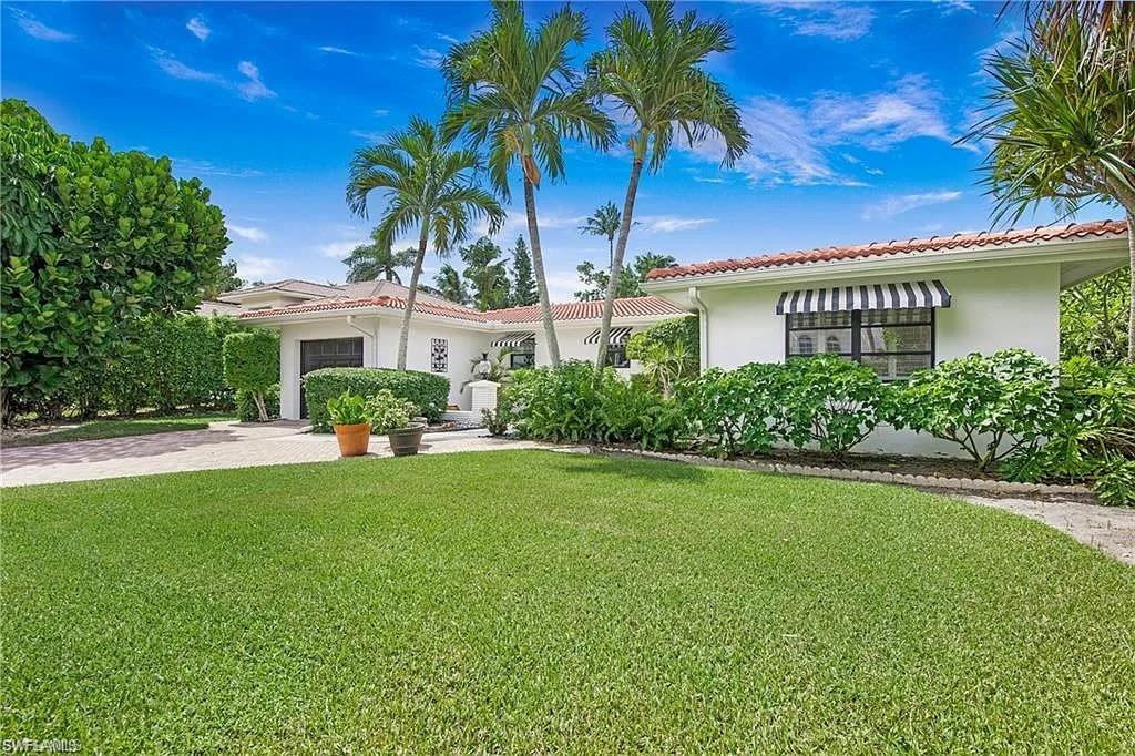 Mediterranean / spanish home with a front lawn, stucco siding, a garage, and driveway
