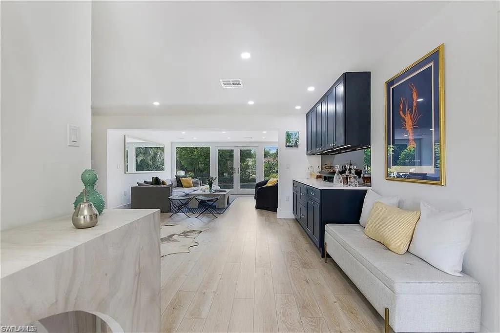 Living area with light wood finished floors, recessed lighting, and french doors