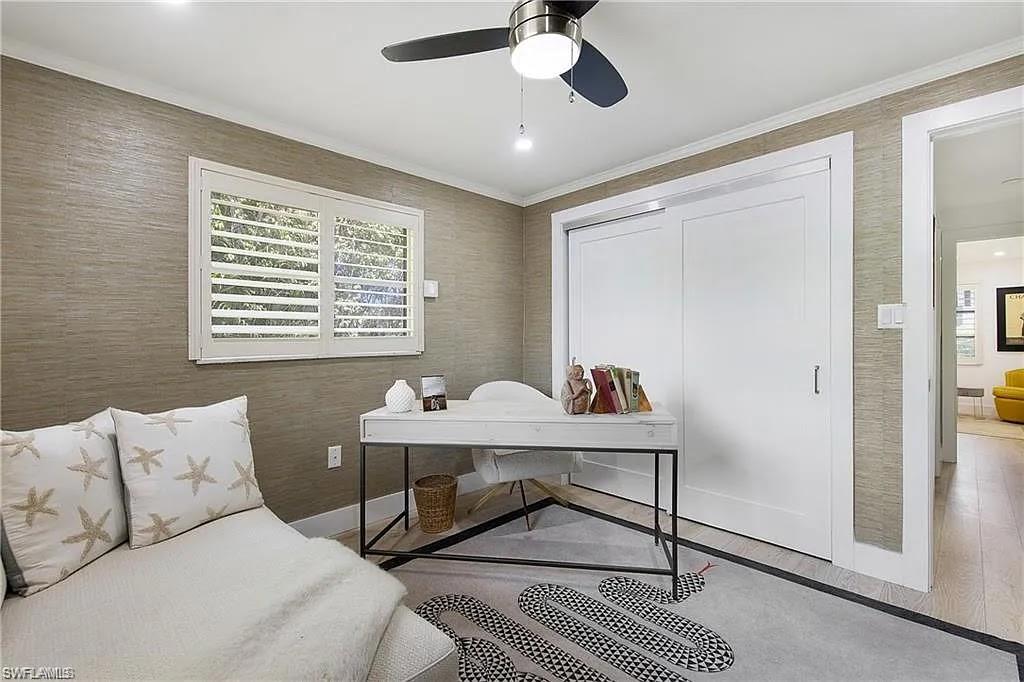 Home office featuring light wood finished floors, a ceiling fan, and crown molding