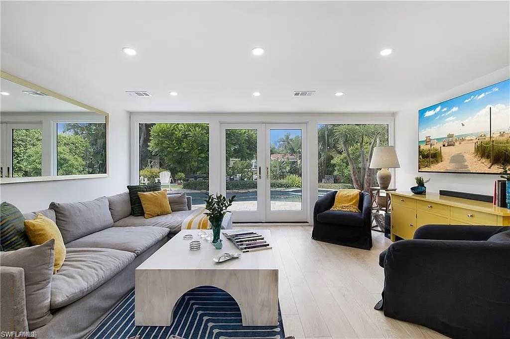 Living room with french doors, light wood finished floors, healthy amount of natural light, and recessed lighting
