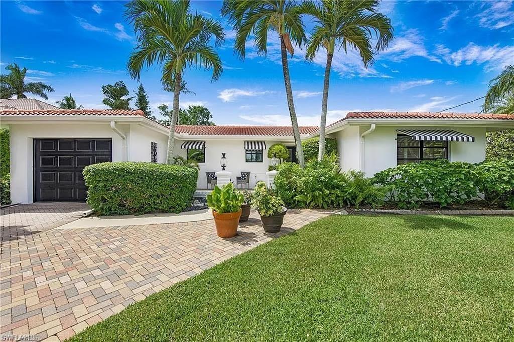 Mediterranean / spanish-style house featuring a garage, stucco siding, a front yard, and decorative driveway