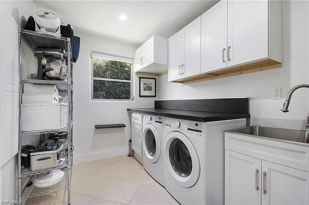 Laundry room featuring light tile patterned floors, washer and dryer, cabinet space, and recessed lighting