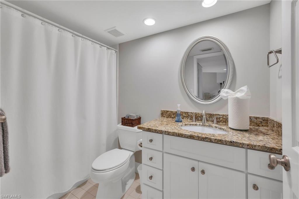 Bathroom featuring updated vanity & counters, a shower with curtain, recessed lighting, and light tile patterned flooring