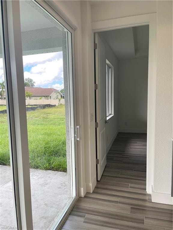 Corridor featuring baseboards and wood tiled floors