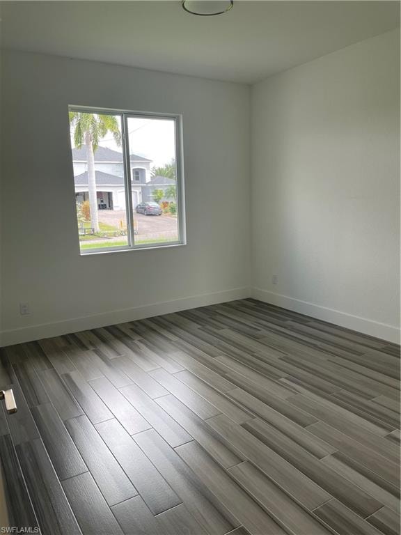 Unfurnished room with wood finish floors and baseboards