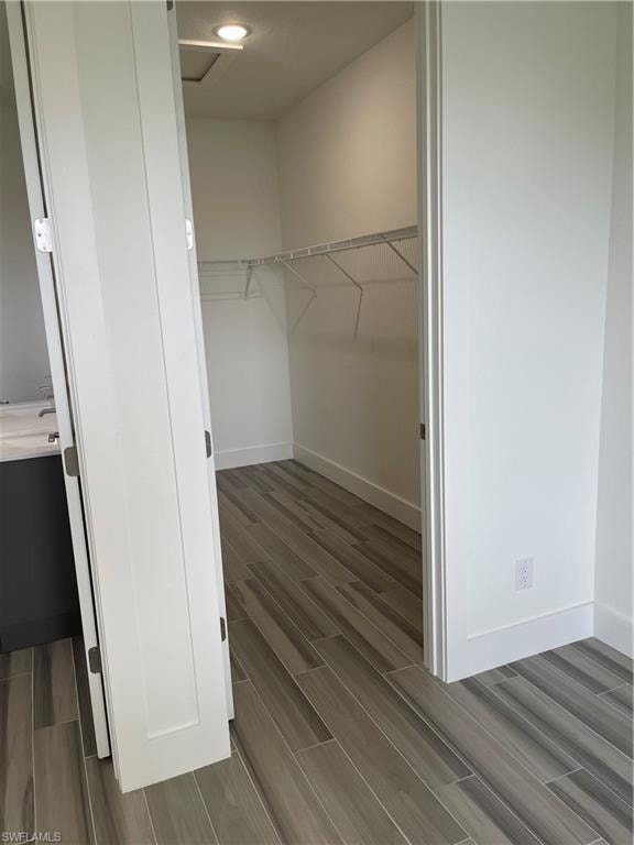 Walk in closet with wood tiled floors