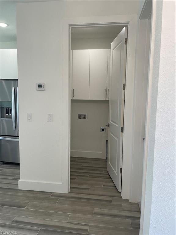 Laundry area featuring hookup for an electric dryer, cabinet space, wood tiled floors, and washer hookup