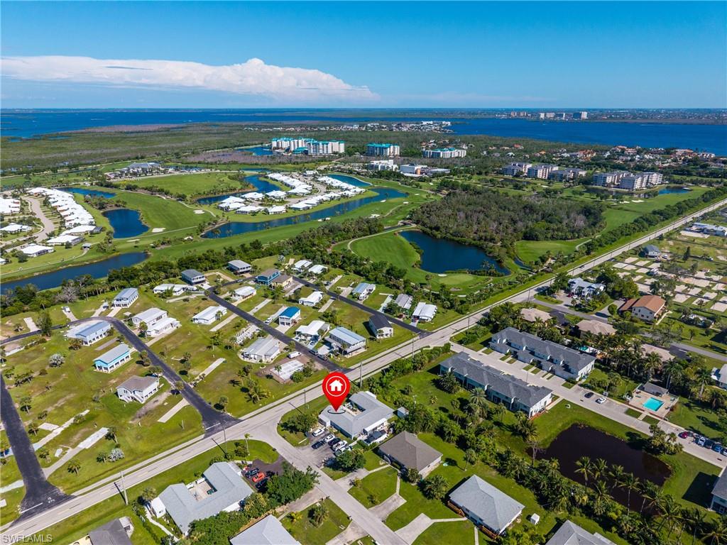 Aerial perspective of suburban area with a large body of water and a golf course