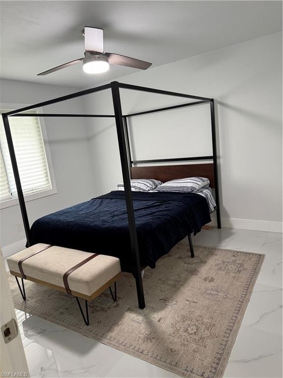 Bedroom with light marble finish floors and ceiling fan