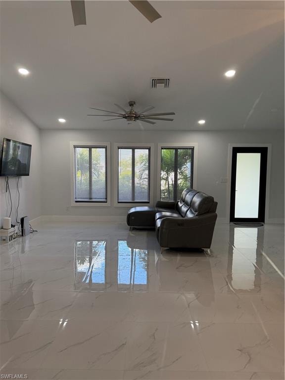 Living area with light marble finish floors and recessed lighting