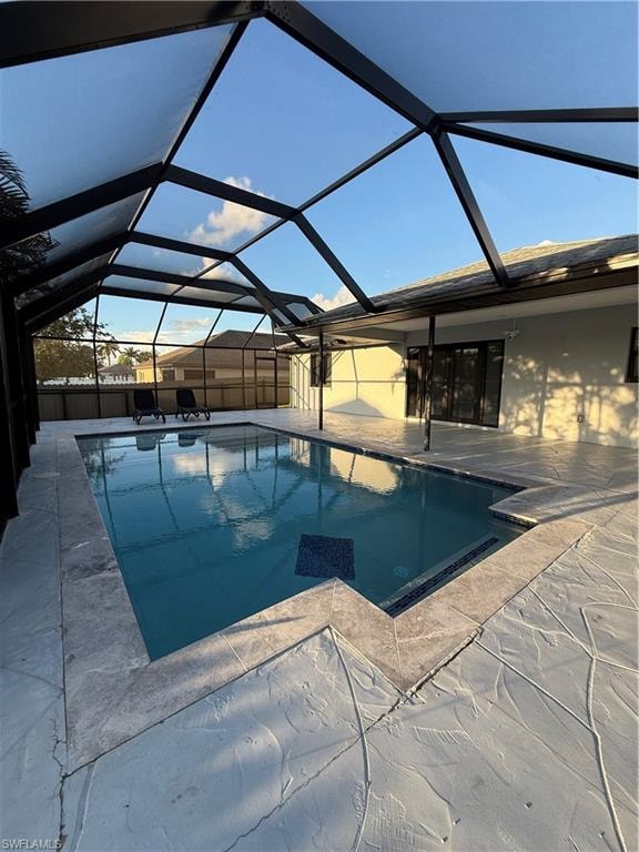 Swimming pool with a sunroom, a lanai, and a patio area