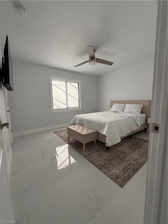 Bedroom with marble finish floors and a ceiling fan