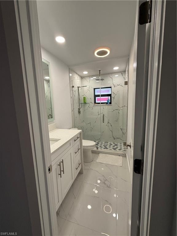 Bathroom featuring light marble finish flooring, a marble finish shower, vanity, and recessed lighting