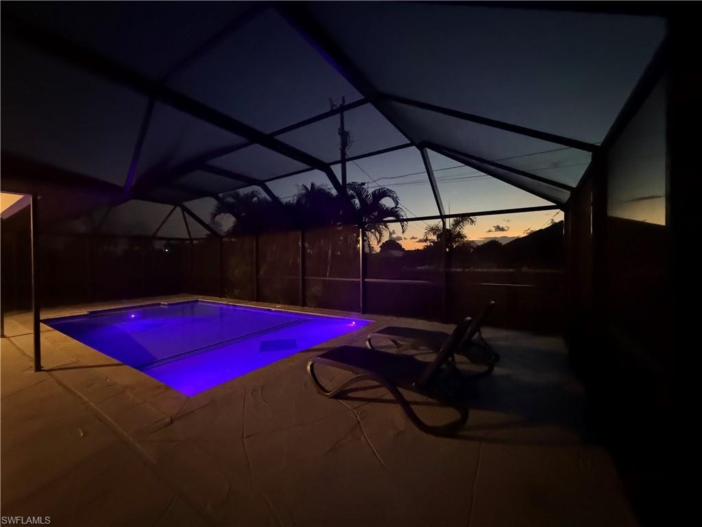 Outdoor pool featuring a sunroom, a patio, and a lanai