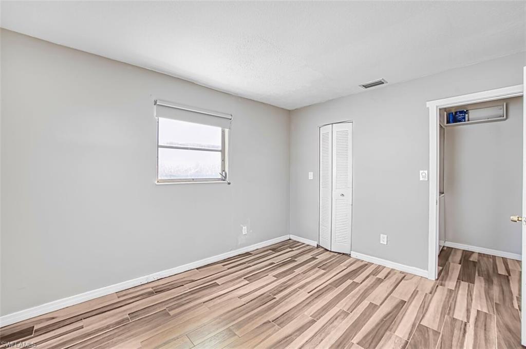 Unfurnished bedroom with wood finish floors and a closet