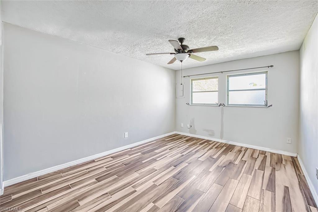 Spare room featuring wood tiled floors, a ceiling fan, and a textured ceiling