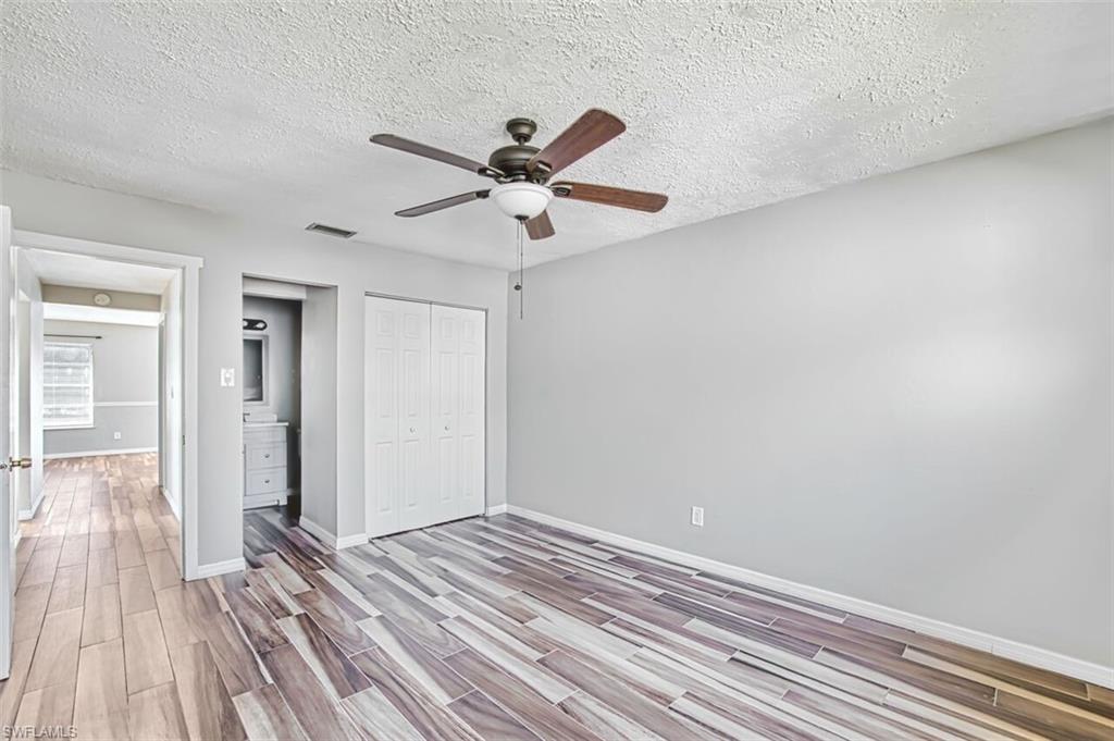 Unfurnished bedroom featuring wood tiled floors, a textured ceiling, ceiling fan, and a closet