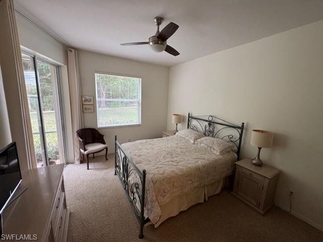 Bedroom featuring access to exterior, dark colored carpet, and ceiling fan