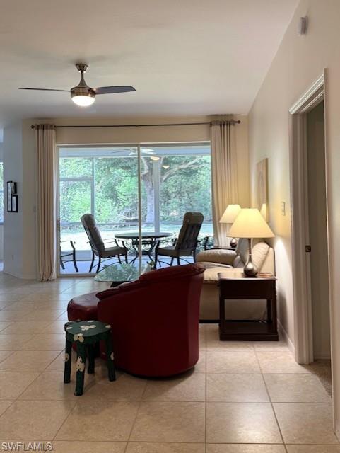Living area featuring light tile patterned flooring and a ceiling fan