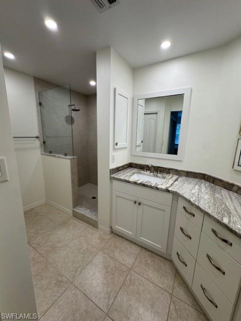 Bathroom featuring vanity, walk in shower, and light tile patterned floors