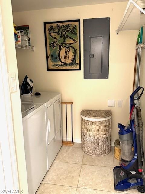 Laundry area featuring electric panel, light tile patterned floors, and separate washer and dryer