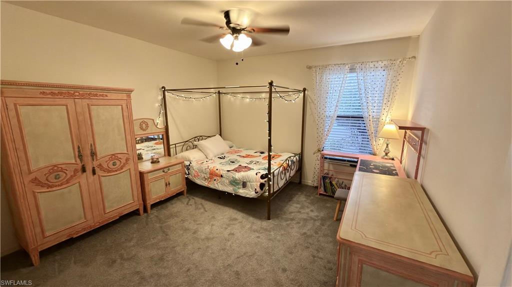 Bedroom with dark carpet and ceiling fan