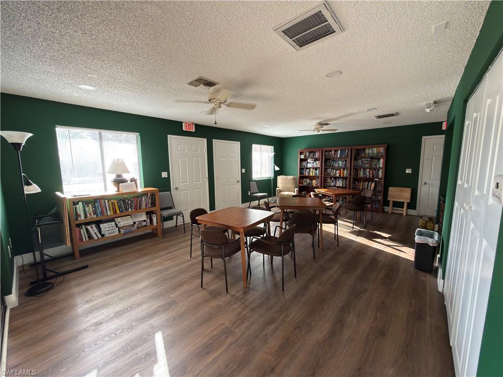 Dining space with dark wood finished floors, a textured ceiling, and ceiling fan