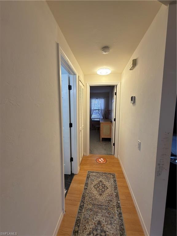 Corridor with light wood-style flooring