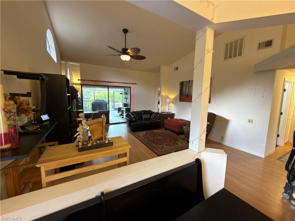 Living room featuring vaulted ceiling, light wood-type flooring, and ceiling fan