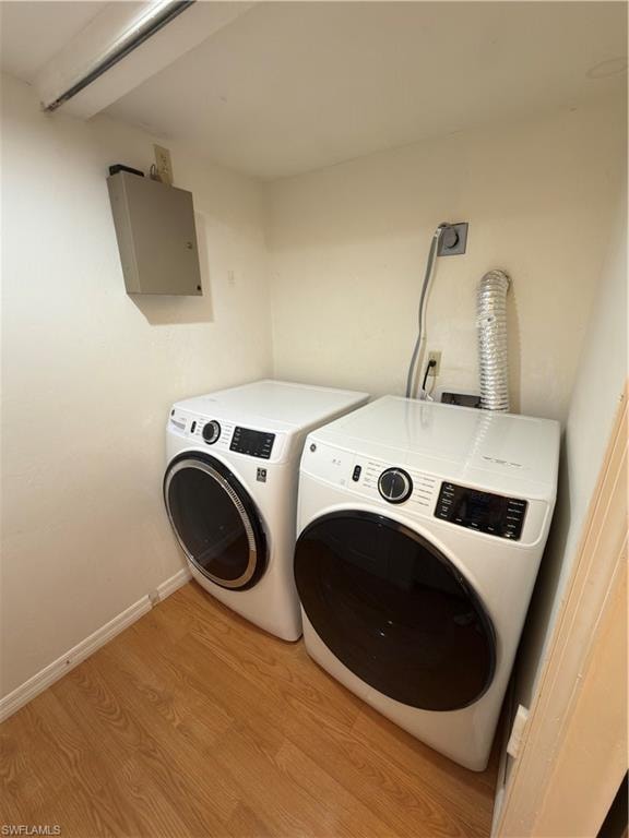 Laundry area featuring washer and clothes dryer and light wood-type flooring