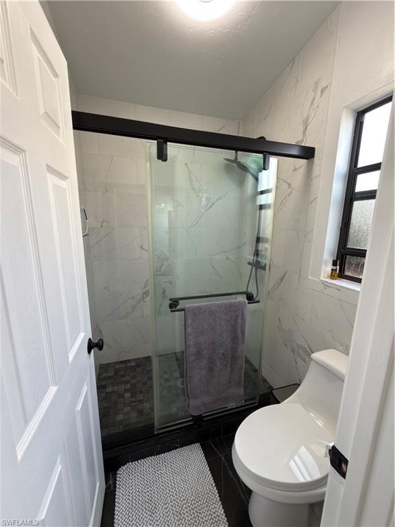 Full bathroom with a marble finish shower and tile walls