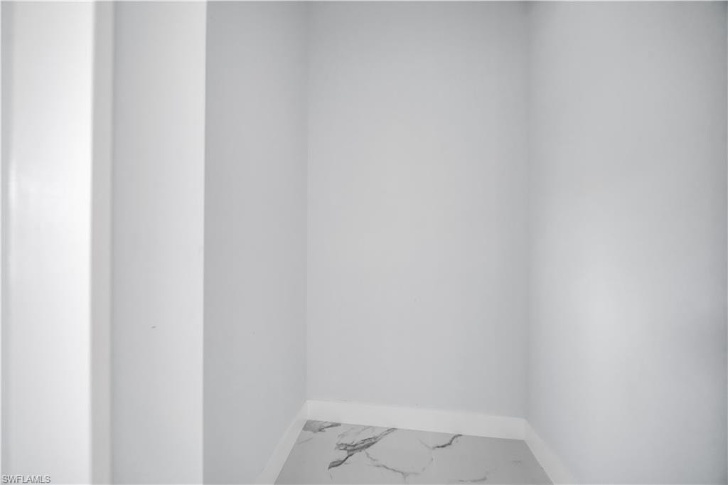 Spare room featuring baseboards and marble look tile flooring